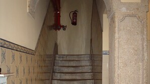 Un escalier avec un extincteur fixé au mur, juste au-dessus.