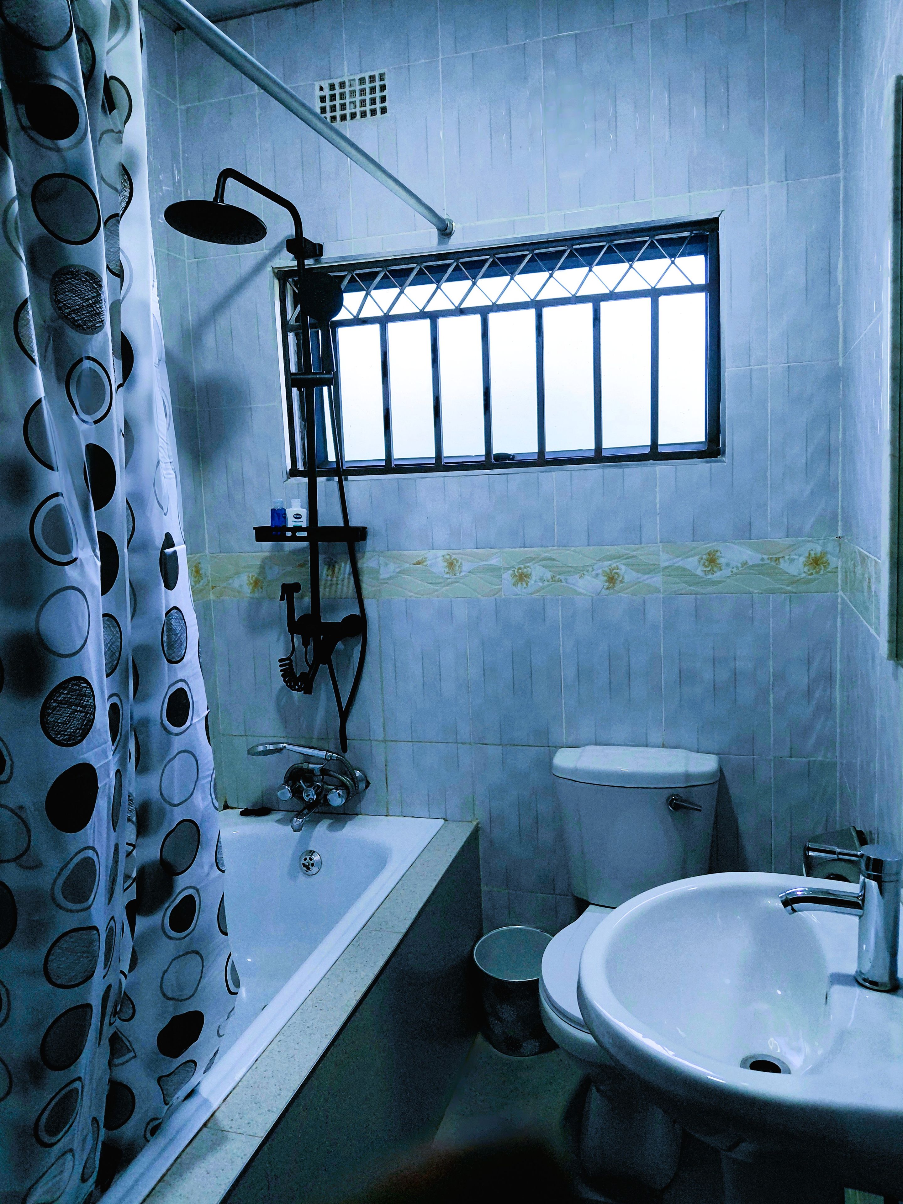 Et badeværelse med badekar, toilet og håndvask.