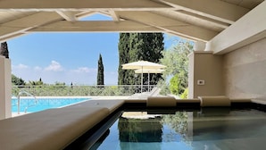 Una piscina interior con vistas despejadas del paisaje circundante, incluyendo árboles y una lejana perspectiva del cielo.