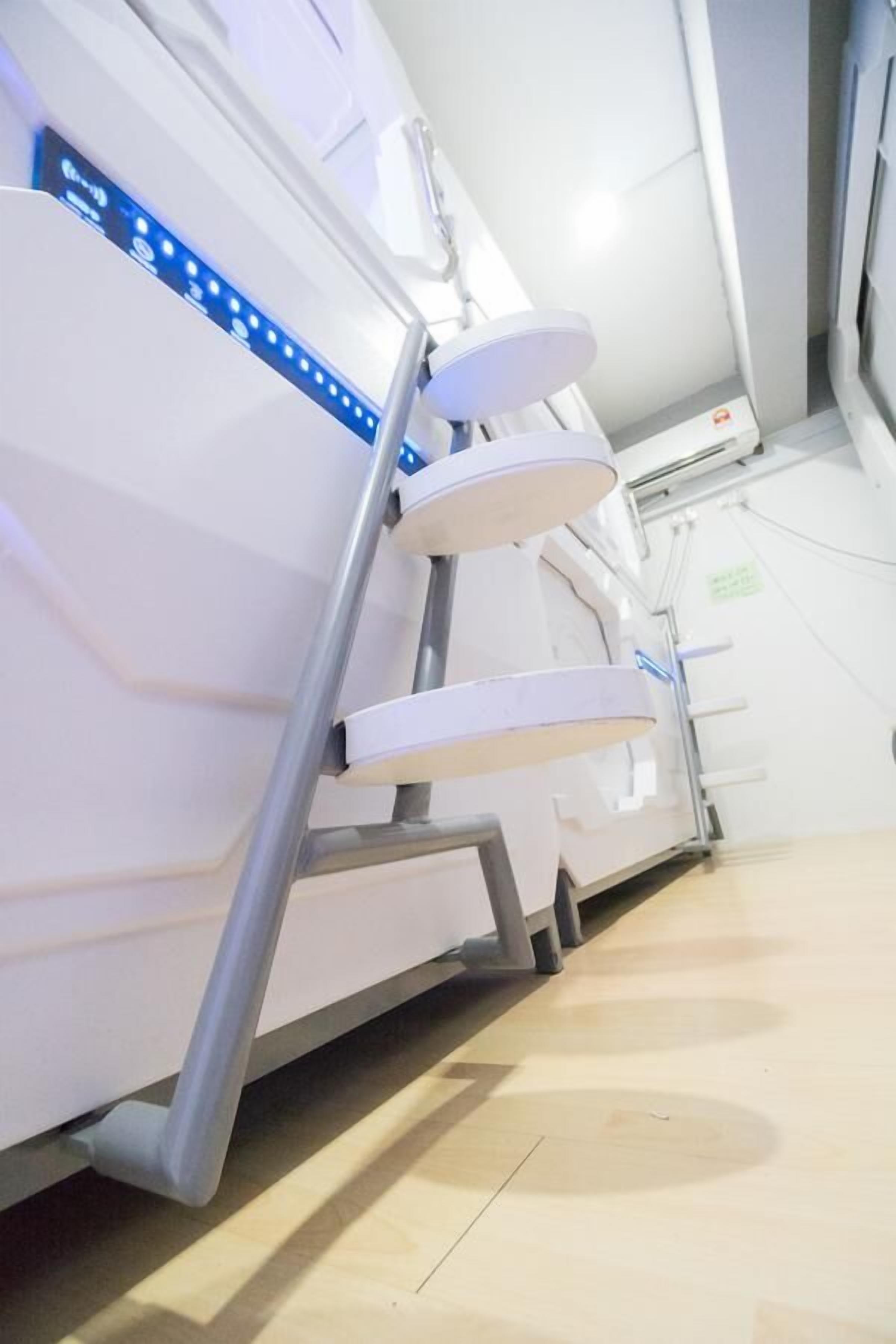 A medical imaging machine with a control panel and a chair.