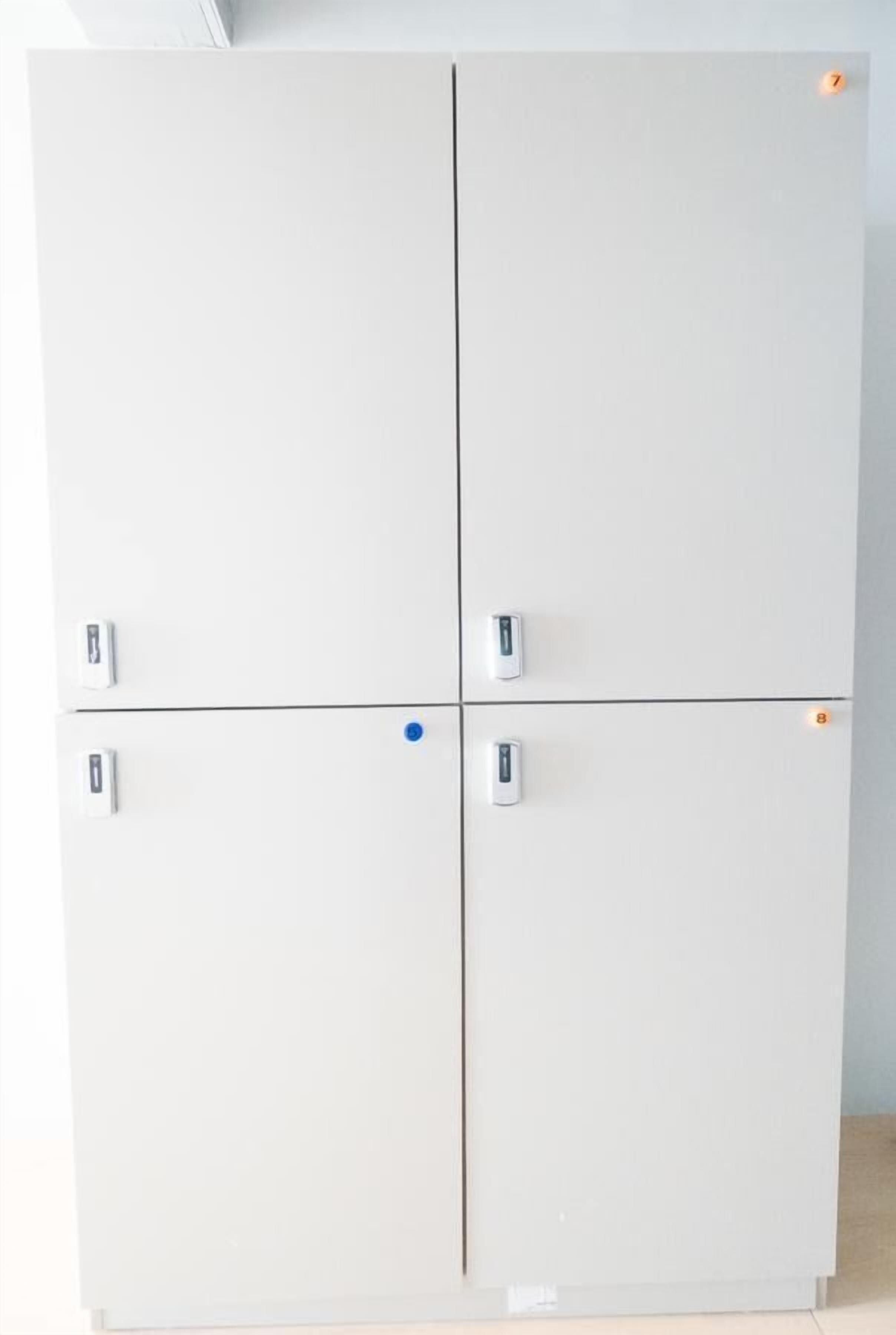 Un armari blanc de quatre portes amb nombroses nenes i un punt blau a una porta.