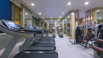 A gym with treadmills, weight machines, and mirrors.