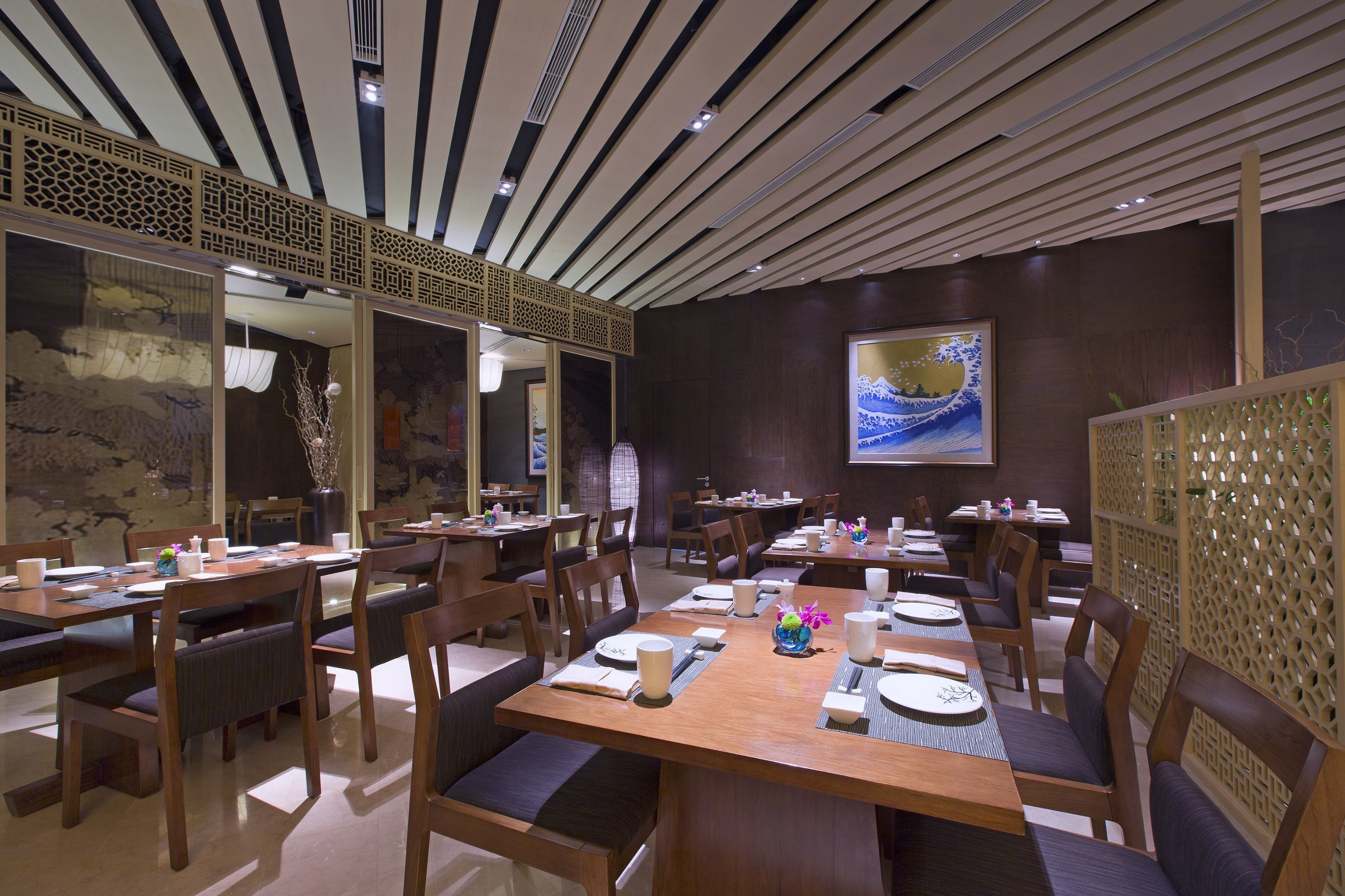 A restaurant with wooden tables and chairs, a decorative ceiling, and a painting on the wall.