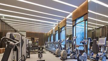 A modern gym with treadmills, elliptical machines, and weight equipment.
