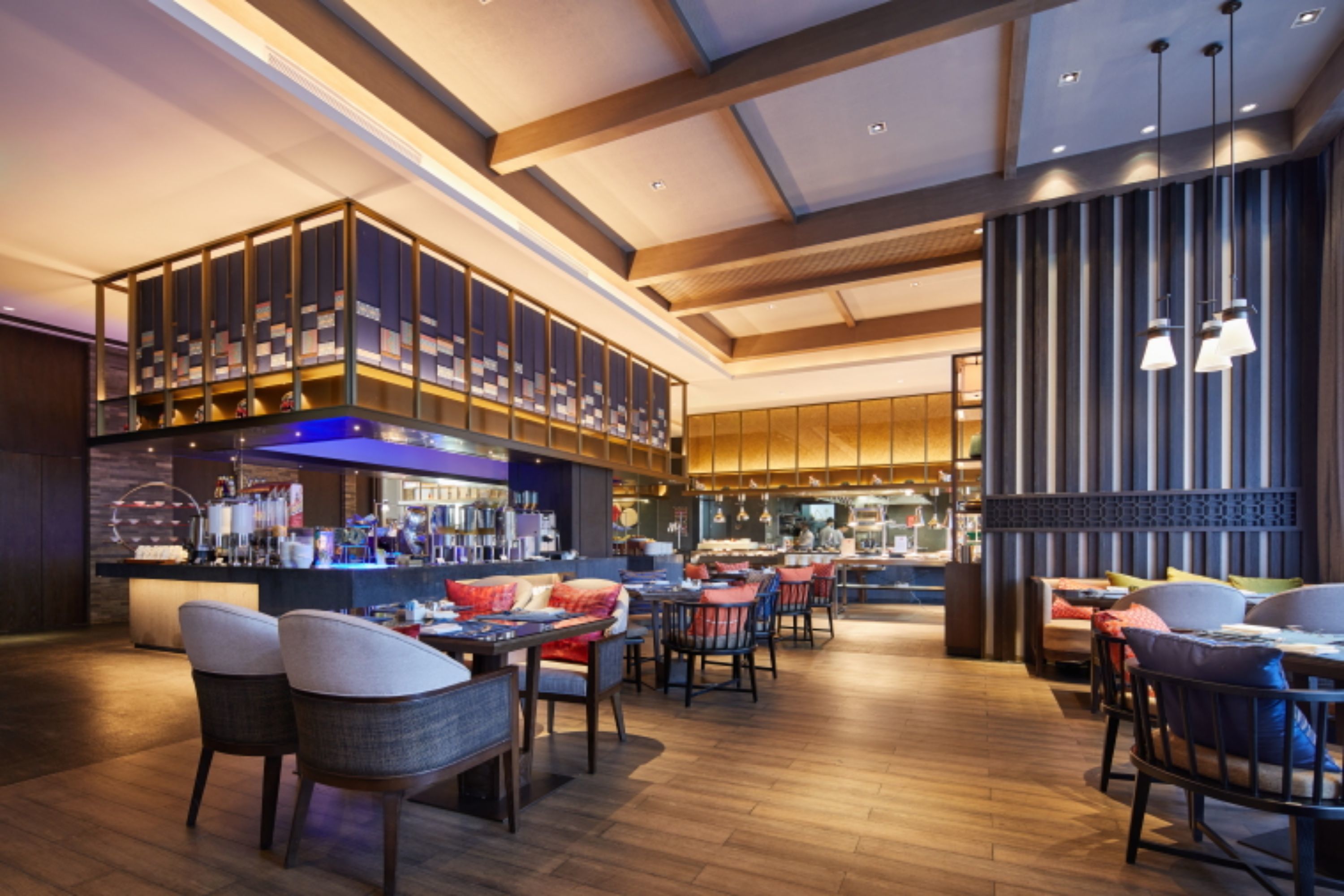 A modern restaurant with a bar area, wooden flooring, and contemporary furniture.