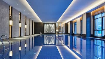 Een binnenzwembad, een buitenzwembad en ligstoelen