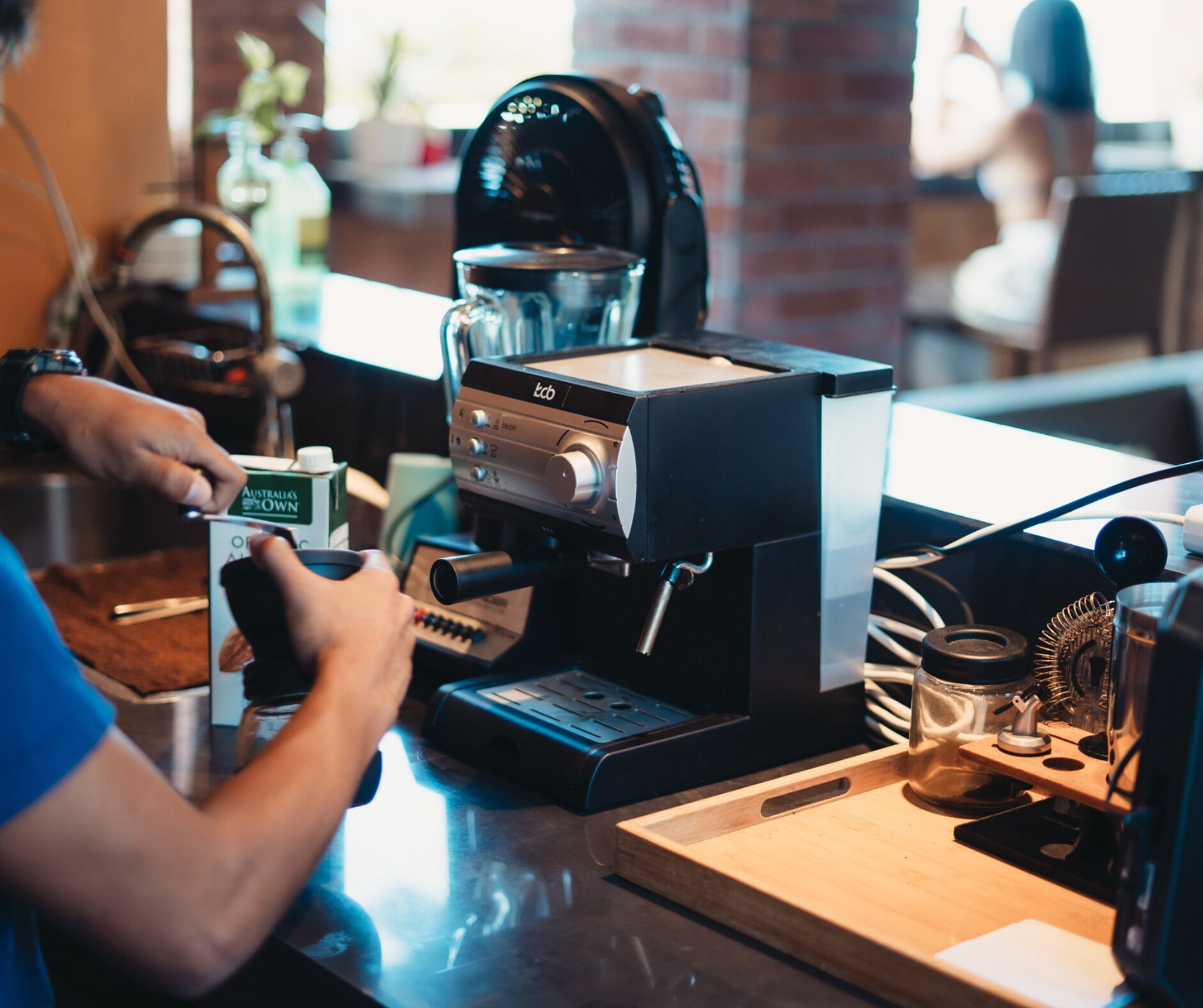 A coffee machine with a digital display and a person using it.