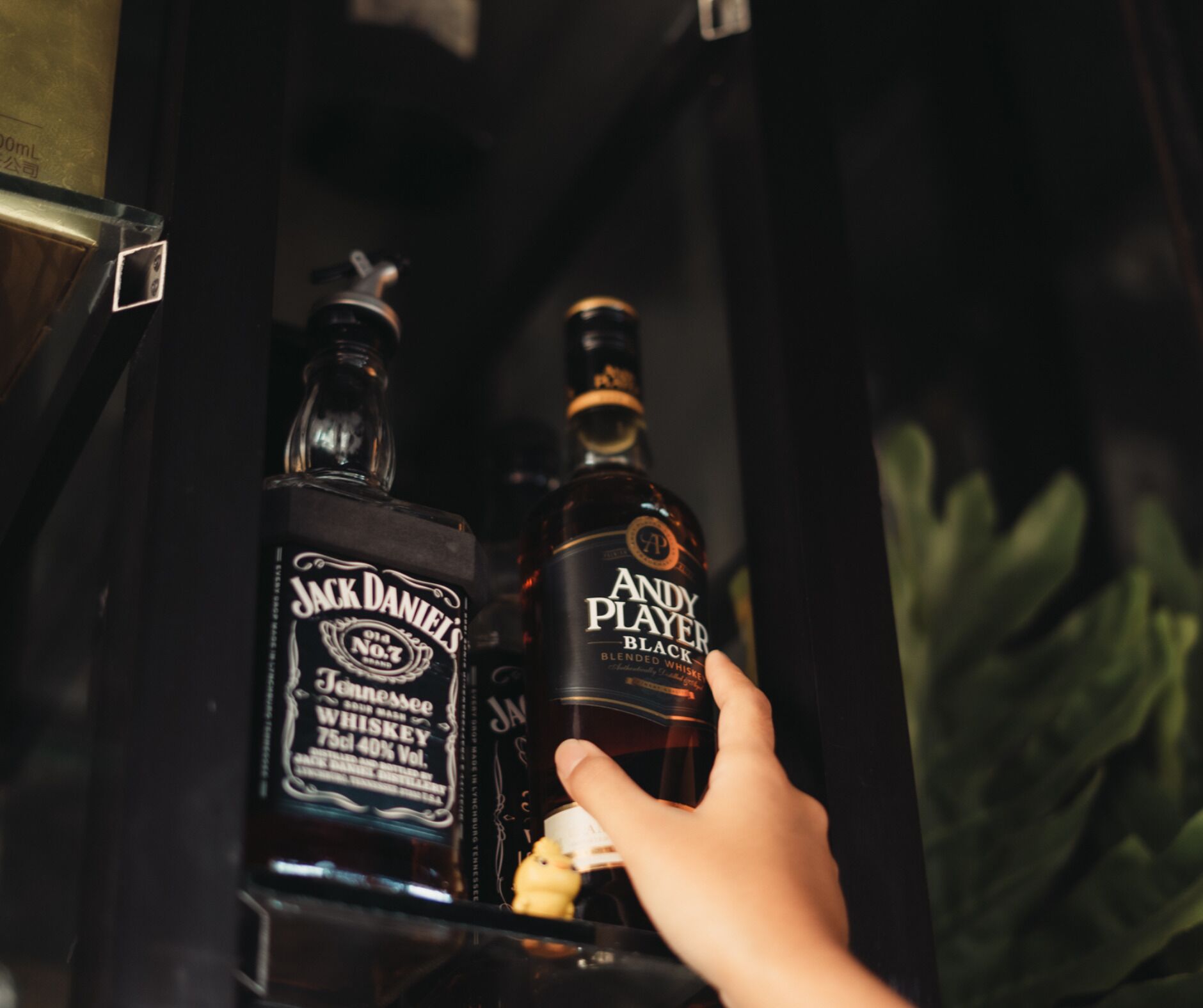Una mano sosteniendo una botella de whisky Jack Daniel's.