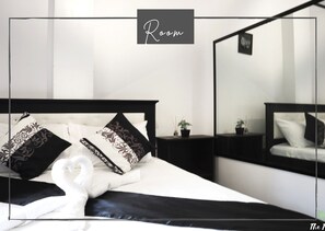 Restful retreat with a large bed, decorative pillows, and a potted plant.