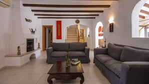 A spacious living room with two grey sofas, a wooden coffee table, and a fireplace.