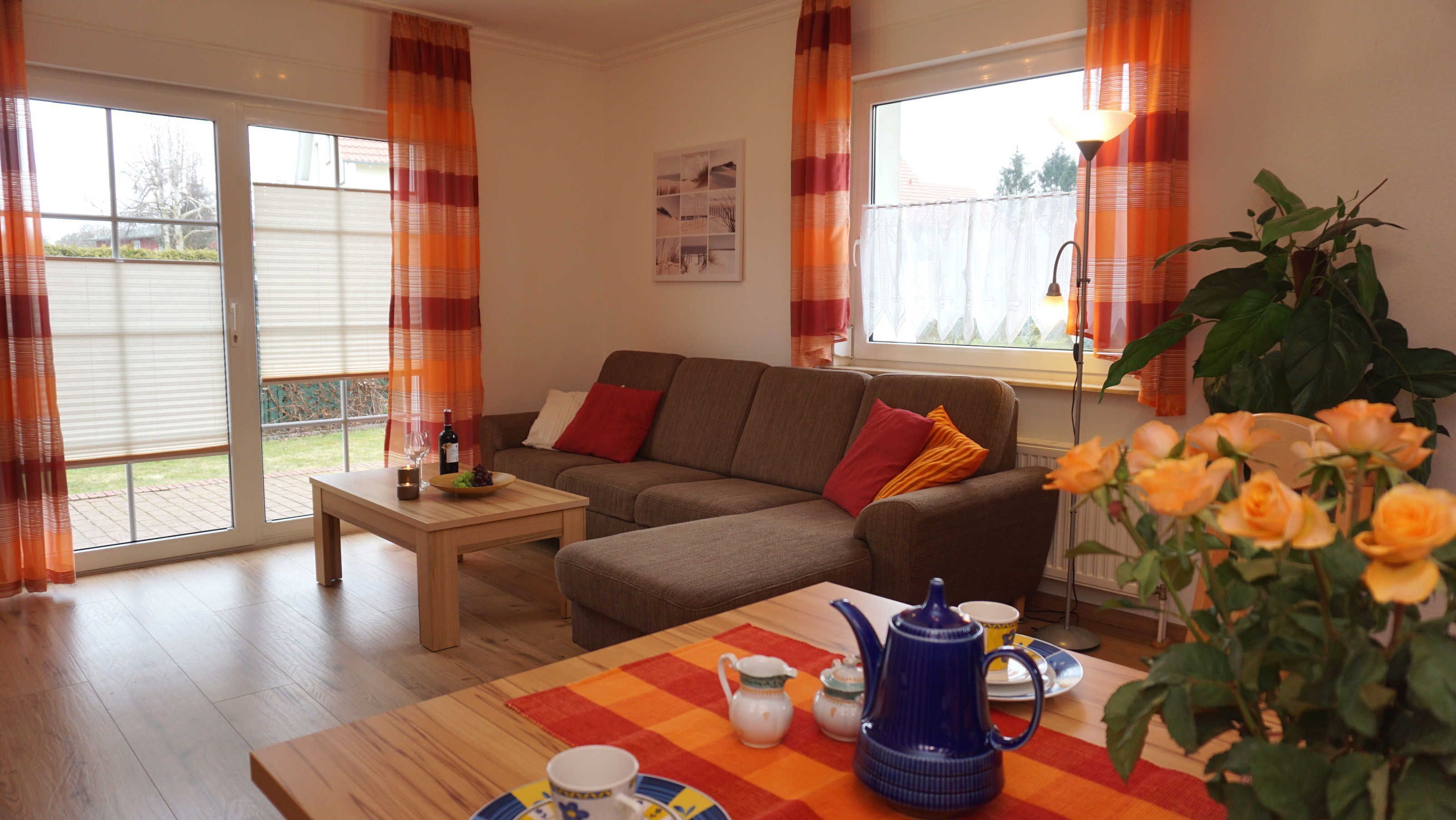 A cozy living room with a sofa, a coffee table with a teapot, and a potted plant.