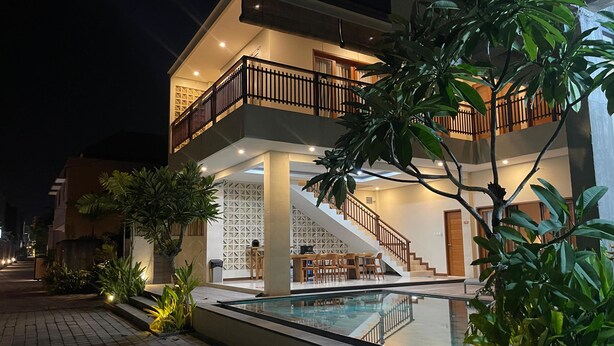 A modern two-story building with a pool, outdoor seating, and a staircase leading to the upper floor. - Lovecho Villa & Room Unit Canggu (Canggu)