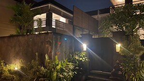 A modern building with a balcony, a gated entrance, and a statue. - Lovecho Villa & Room Unit Canggu (Canggu)