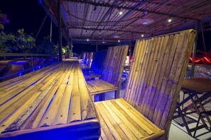 Eine Holzterrasse im Freien mit Sitzgelegenheiten und einem überdachten Bereich.