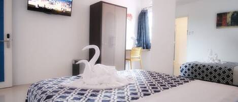 A hotel room with a bed, a television, a wardrobe, and a chair.