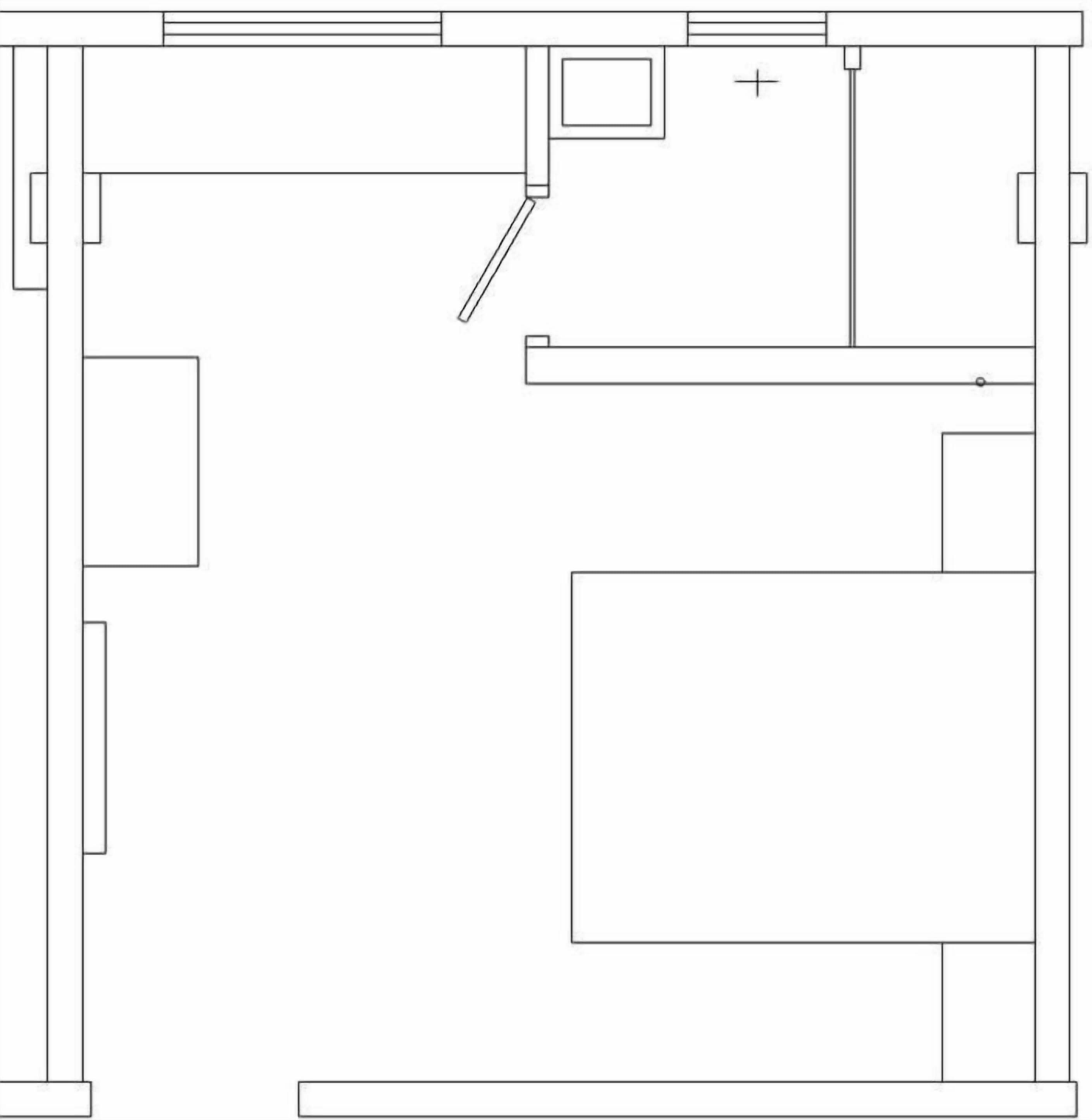 A floor plan with a large central room, a smaller room to the left, and a doorway leading to another room.