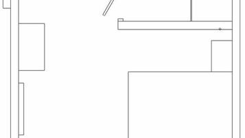 Plano de planta que muestra una habitación central amplia, una habitación más pequeña a la izquierda, y un acceso a otra habitación.