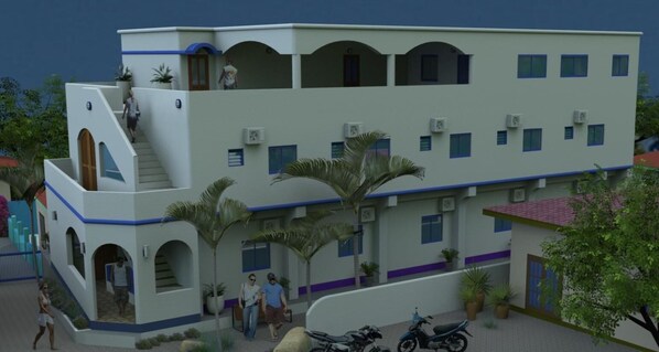 A multi-story building with a central staircase, balconies, and a covered outdoor area with potted plants. - D' Gecko Hotel (Moalboal)