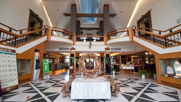 A spacious lobby with a central marble table, wooden railings, and a high ceiling with skylights. - Shin Kong Chao Feng Ranch And Resort (Fenglin)