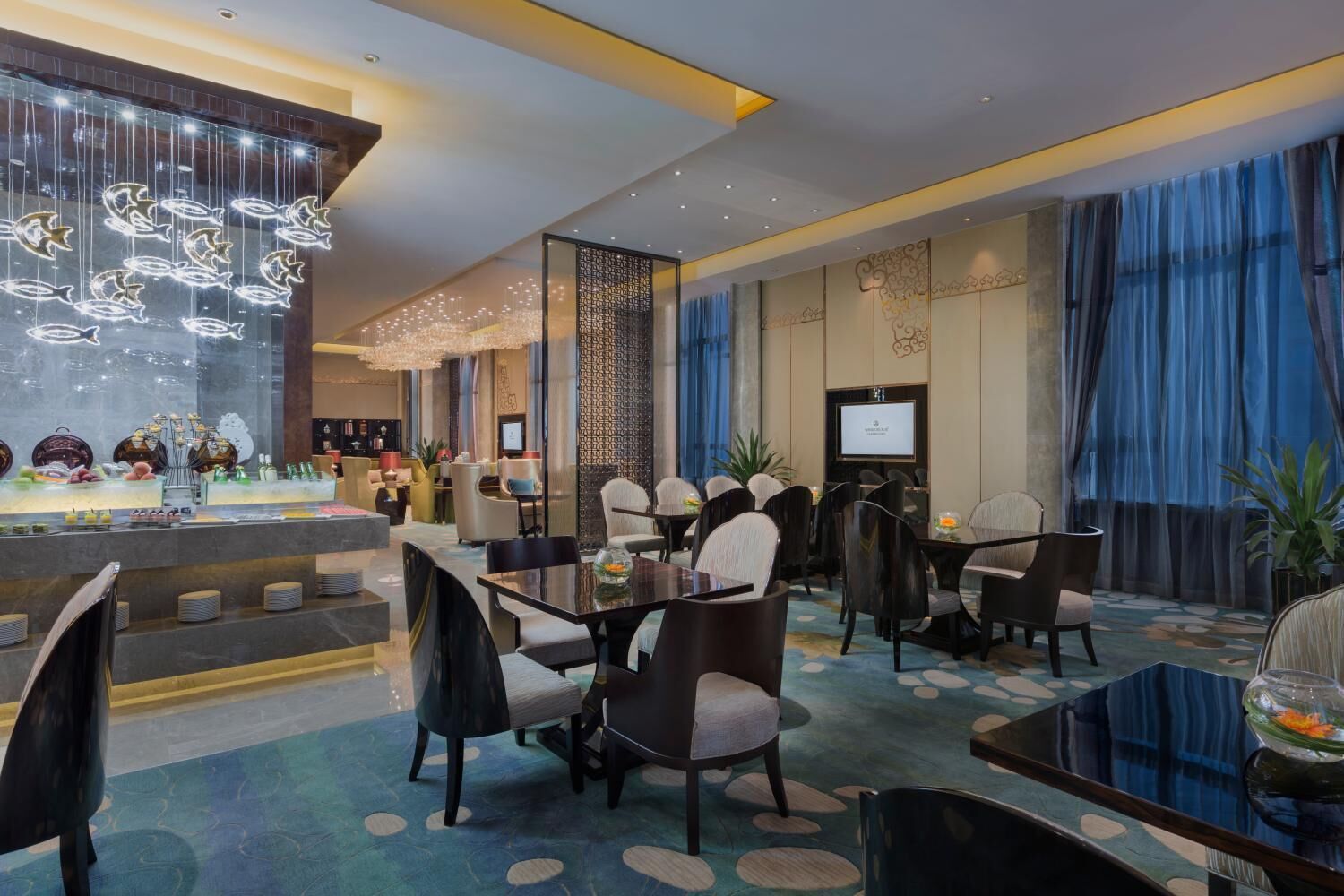 Un moderno vestíbulo de hotel con zona de bar, asientos y detalles decorativos.