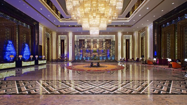 A spacious lobby with a large chandelier, a central fountain, and a patterned floor. - Wanda Vista Quanzhou (Quanzhou)