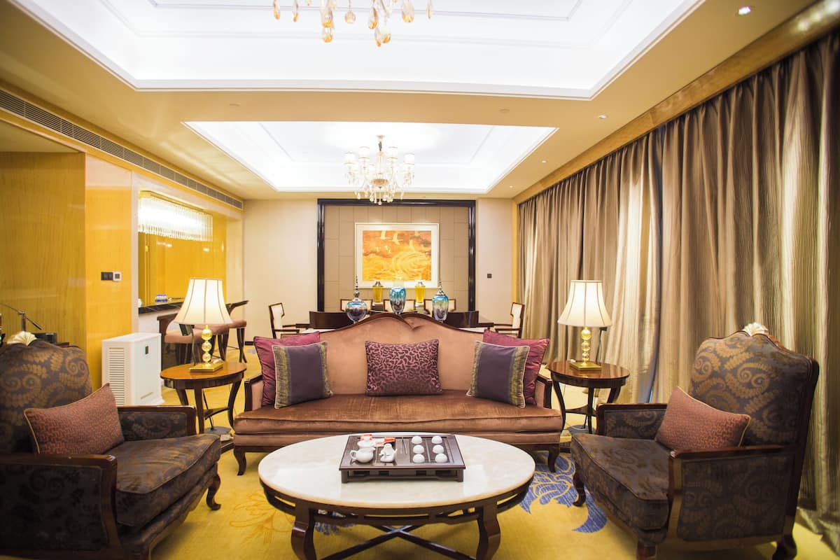 A spacious living room with a sofa set, a coffee table, and two side tables with lamps.