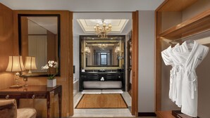 A hotel bathroom with a large mirror, a chandelier, a vanity with a sink, and a robe rack. - Wanda Vista Quanzhou (Quanzhou)