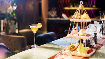 Un bar con una copa de martini y un pastel de varios niveles.
