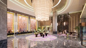 A spacious lobby with a large chandelier, marble flooring, and a reception desk. - Wanda Realm Maanshan (Ma'anshan)