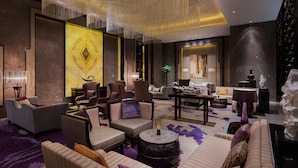 Eine moderne Hotellobby mit verschiedenen Sitzgelegenheiten, darunter Sofas, Sessel und ein runder Couchtisch.