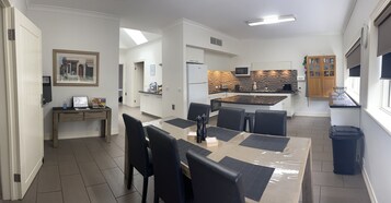 Cocina moderna con microondas, estufa y armarios. Cuenta con una zona de comedor con mesa y sillas.