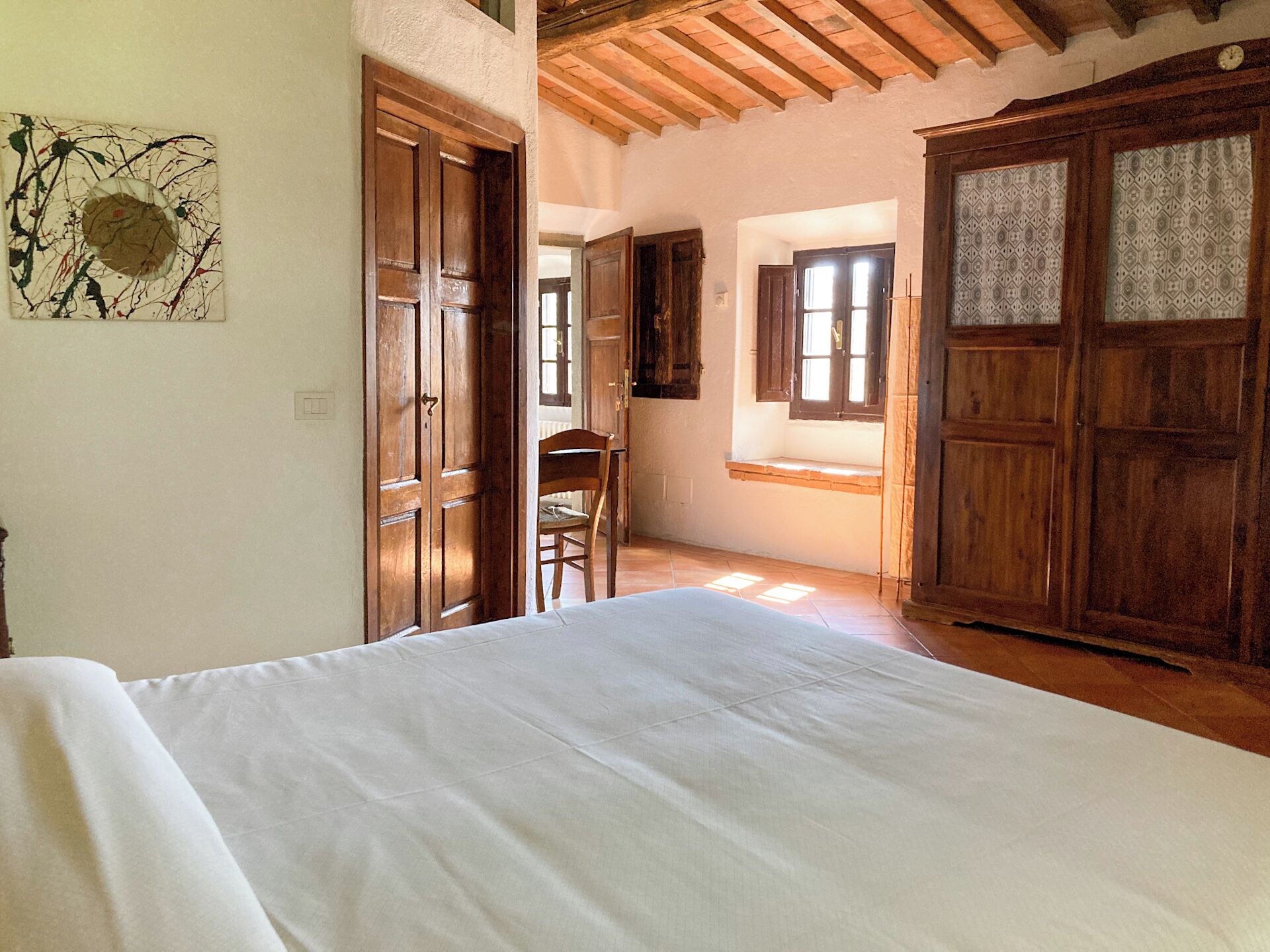Una camera da letto con un letto, un armadio in legno e una sedia.