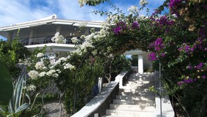 Una escalera de piedra que lleva a un edificio blanco con balcones.
