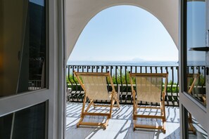 A balcony with two wooden chairs and a view of the sea. - Hotel Punta Scario (Malfa)