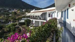 Un edificio blanco con balcones que dan a un paisaje montañoso.