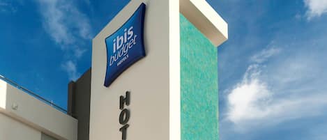 A modern hotel sign with "ibis budget hotels" and "HOTEL" written on it.