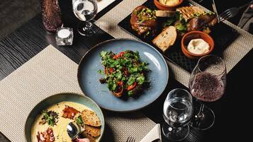 A table set with various dishes, a candle, and glasses of wine.