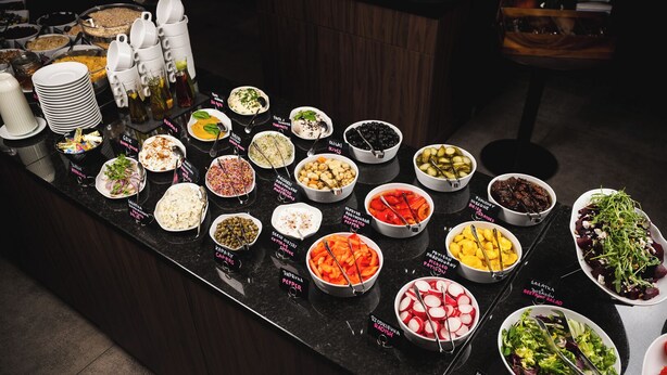A buffet with various dishes labeled in a foreign language. - Hotel Focus Poznań (Poznan)