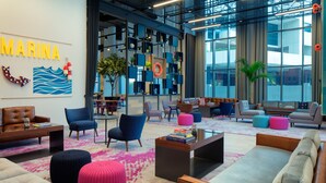 A modern lounge area with seating, a coffee table, and a bookshelf. - Rove Dubai Marina (Dubai)