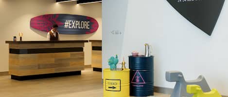 A reception desk with a #EXPLORE sign, a location marker for Marina, and two barrels labeled "TO BEACH" and "GAHWA ZONE".