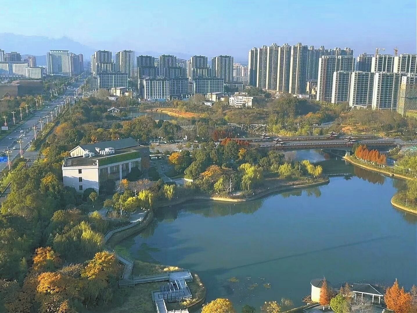 A residential area with high-rise buildings, a lake, and a bridge.