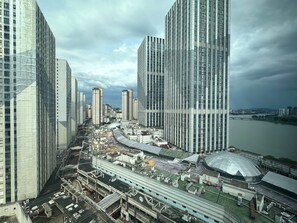 Un quartier urbain dense, avec de grands immeubles modernes, une rivière et un pont.