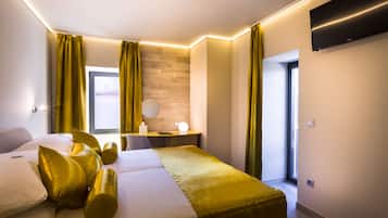 Un hotel moderno con cama, mesita de noche, lámpara y vistas al exterior.