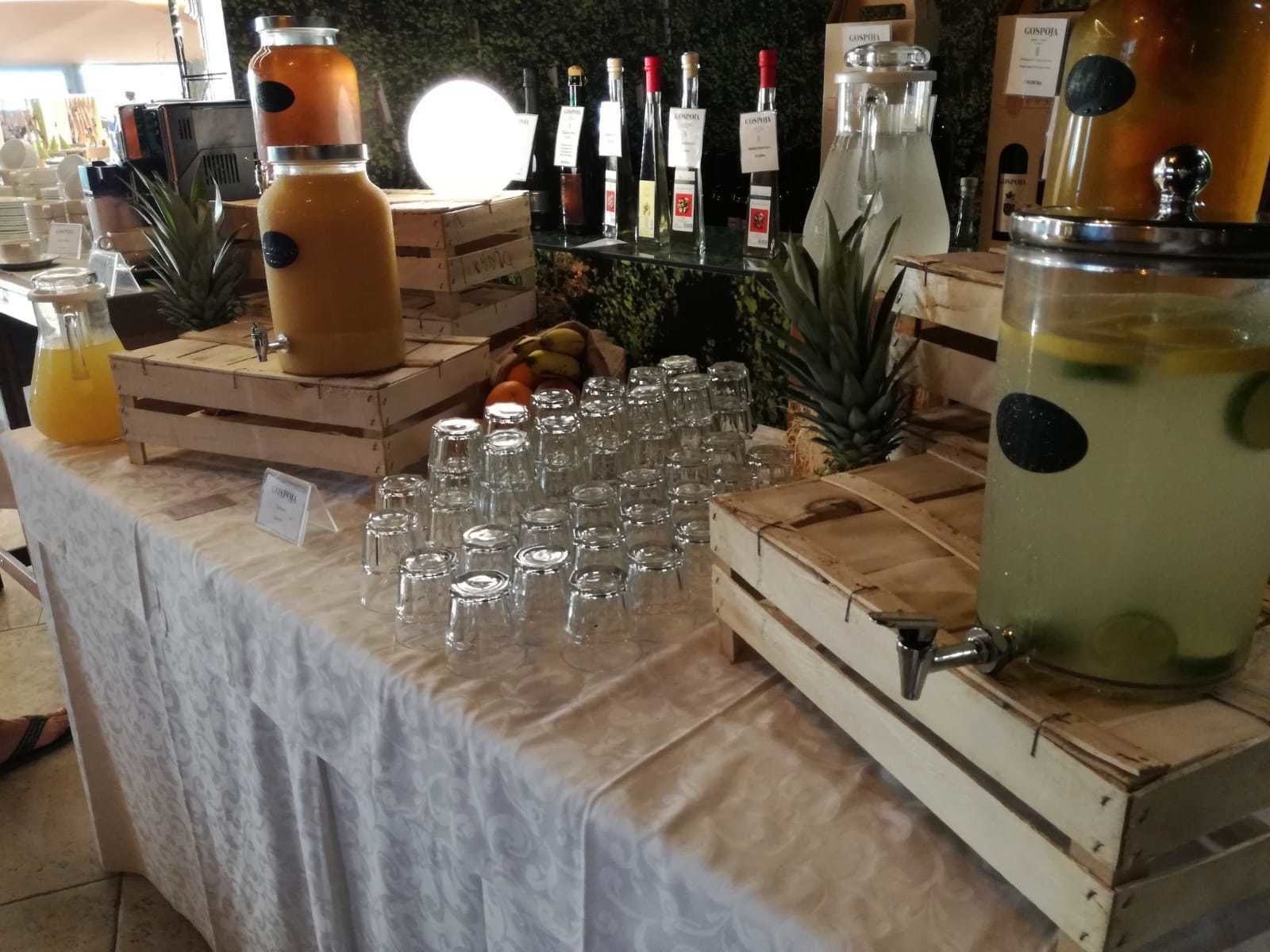 A bar area with multiple drink dispensers, glasses, and bottles.