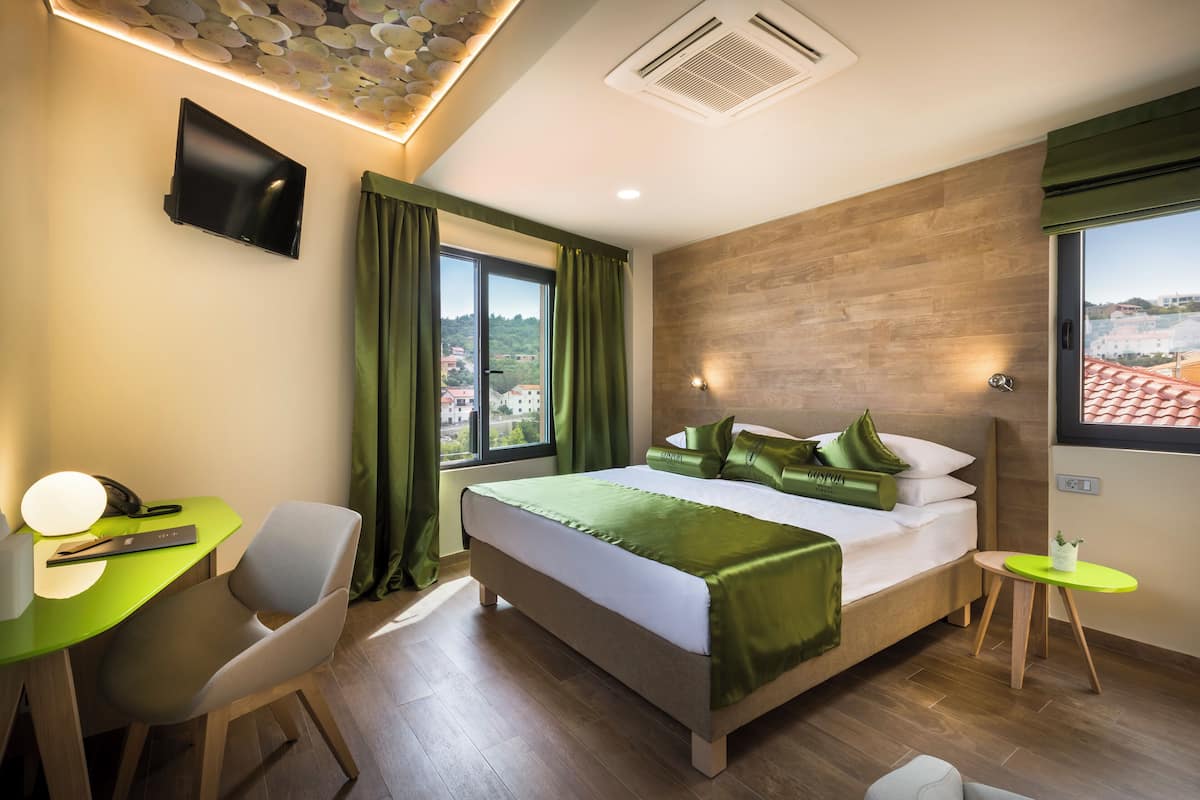 Una habitación de hotel moderna con cama, escritorio, silla y vista a la ciudad.
