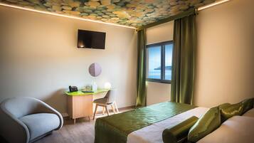 A modern hotel room with a bed, a desk, and a chair.