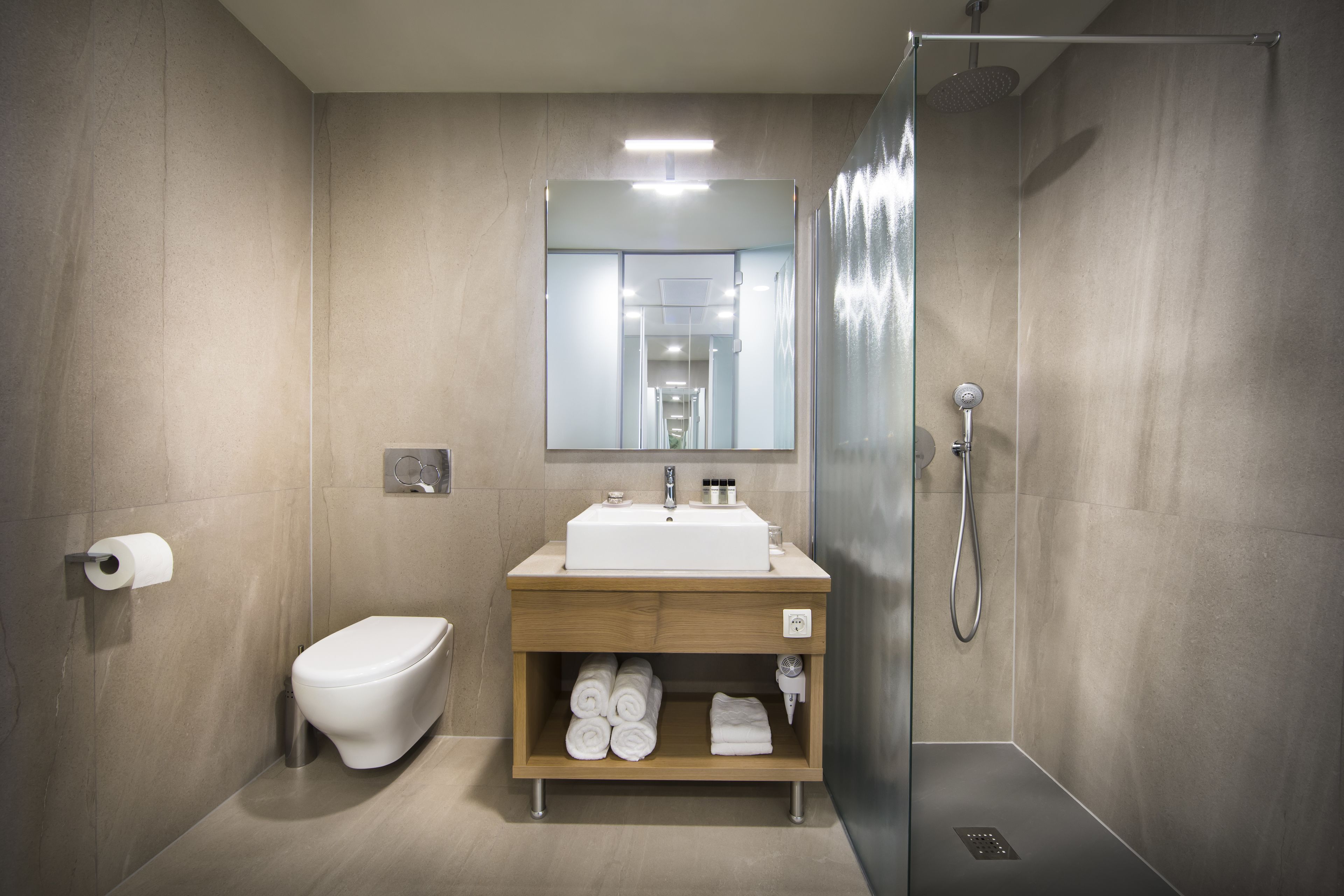 A modern bathroom with a toilet, sink, and shower.