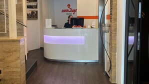 A hotel reception area with a modern design, featuring a reception desk, a staircase, and a glass door entrance. - sevenDays Hotel BoardingHouse (Karlsruhe)