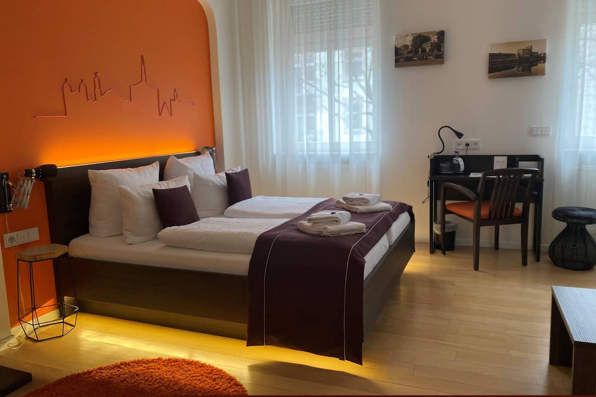 Una habitación de hotel moderna con una cama grande, un escritorio y una silla.