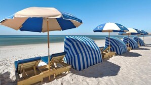 A beach with rows of blue and white striped beach umbrellas and lounge chairs. - TIDEWATER 4th FLOOR - SKIP ELEVATORS! No Windows on Hallway, walk to Pier Park! (Panama City Beach)